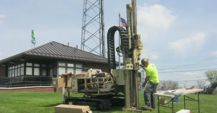 Drill rig sampling soil beside a historic railroad depot
