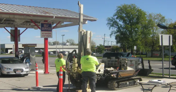 Field crew drilling at a gas station for a UST site check