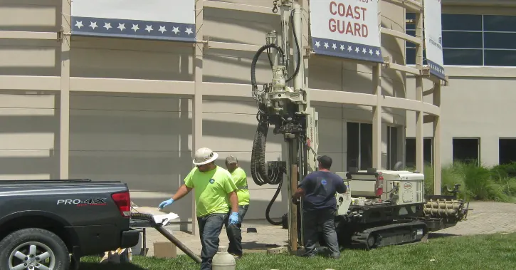 Spence field crew operating a drill rig outside a commercial building